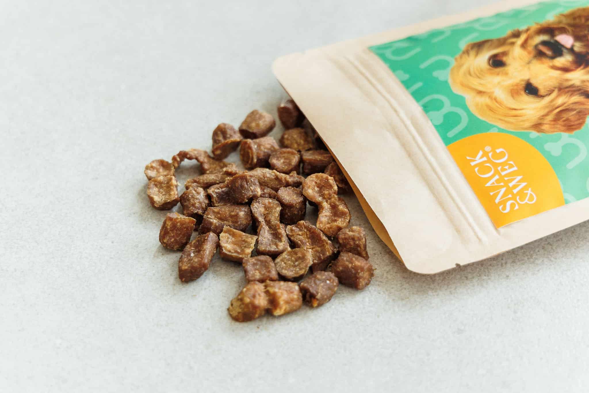 Getreidefreie Hundeleckerlis fallen aus einer Tüte